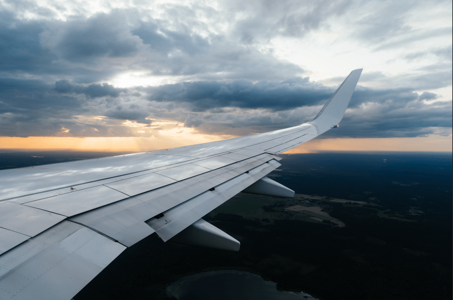 Airplane wing flying above clouds